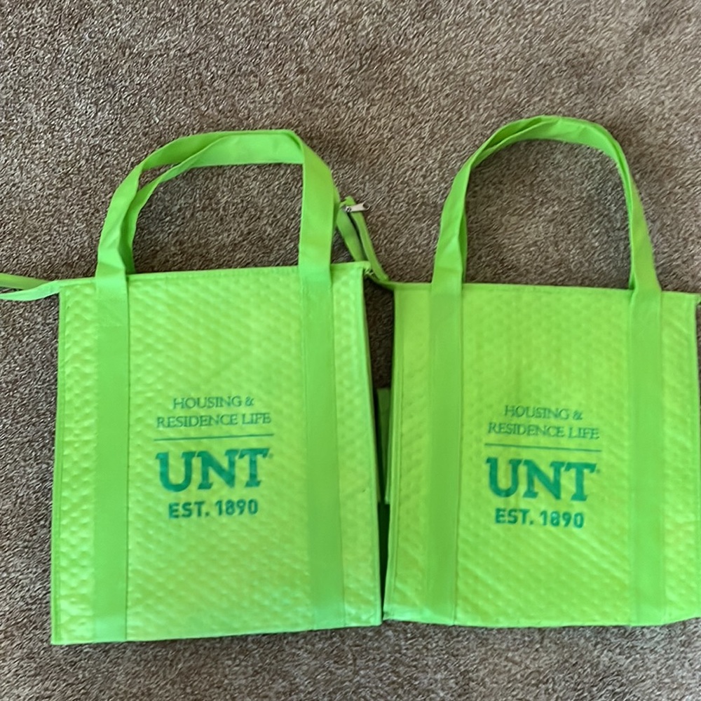 2 Housing & Residence Life green bags for food carrying